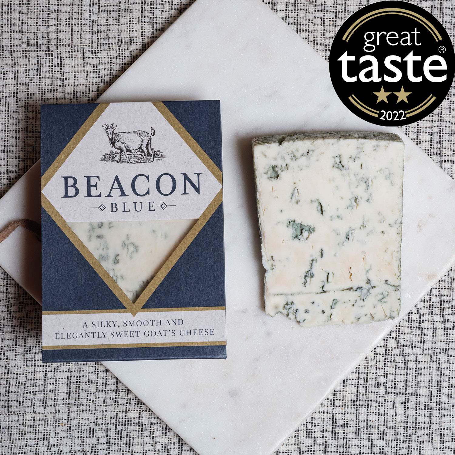 Beacon Blue, our award-winning blue goats cheese, sliced on a cheese board next to it's packaging