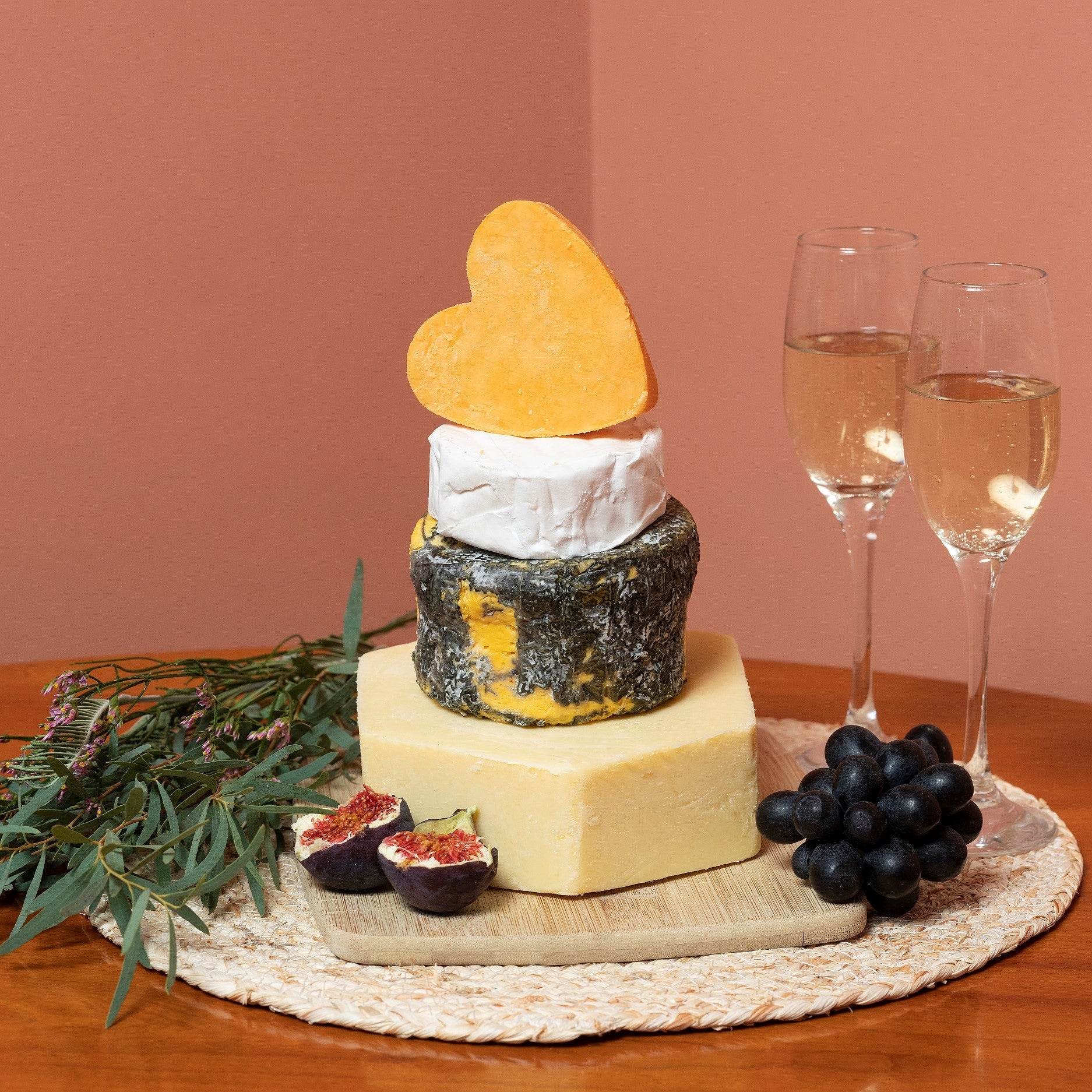 Small cheese wedding cake. Artisan cheese tower of hard, blue and soft cheese, topped with a red Lecister heart shaped cheese.