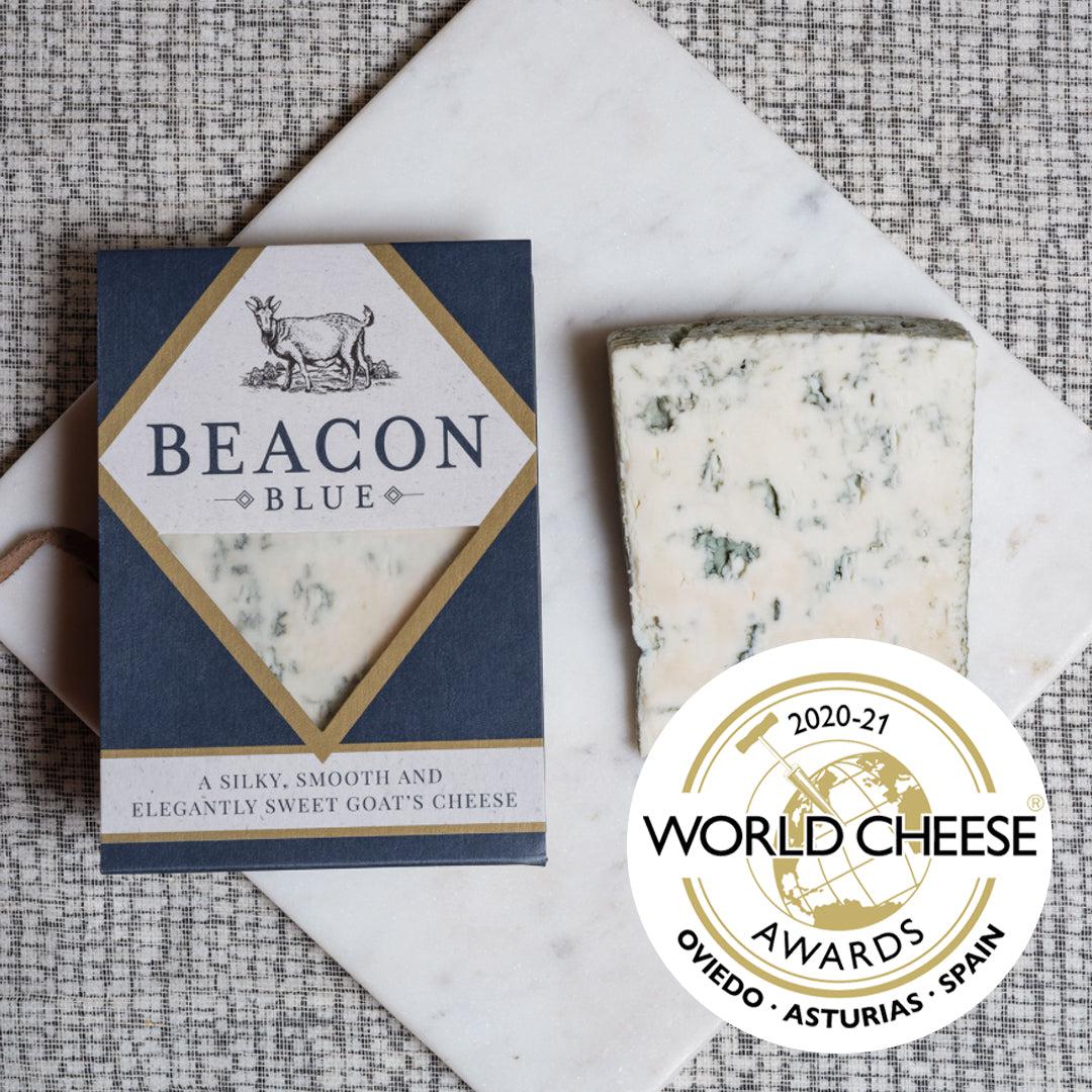 World cheese award winning blue goats cheese, sliced on a cheesboard next to the packaging.