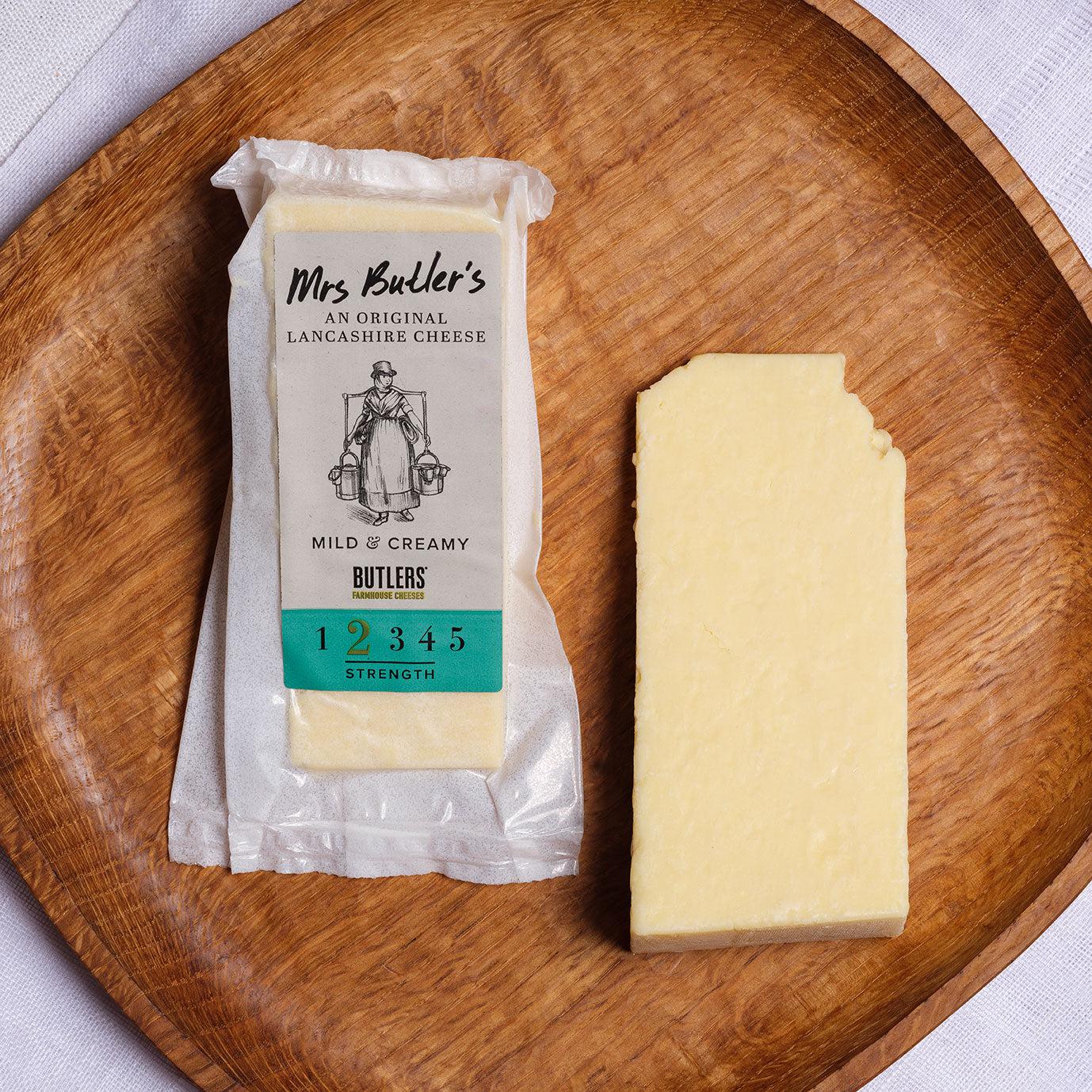Mrs Butler's Farmhouse Creamy Lancashire Cheese on a wooden plate in it's packaging and also as a 200gm cheese wedge.